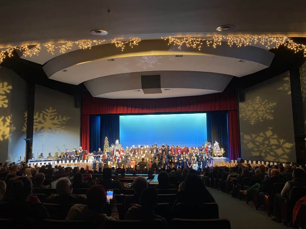 Large choir performing in auditorium.